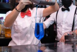 Bartenders wearing masks pouring drink regarding the new COVID-19 rules for pubs in Wales