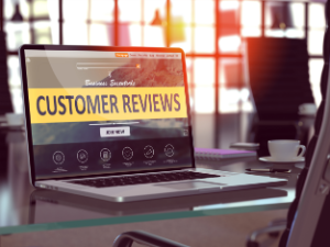 Laptop on glass desk showing a customer reviews screen