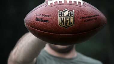 A NFL player holding a football