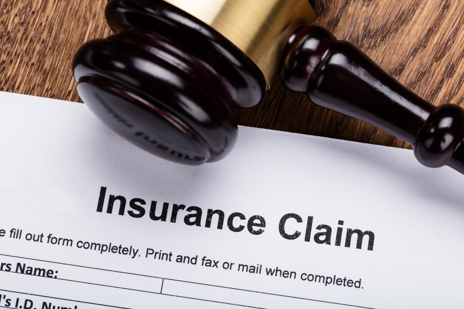 A gavel lies near an insurance claim form on a wood surface - fca test case