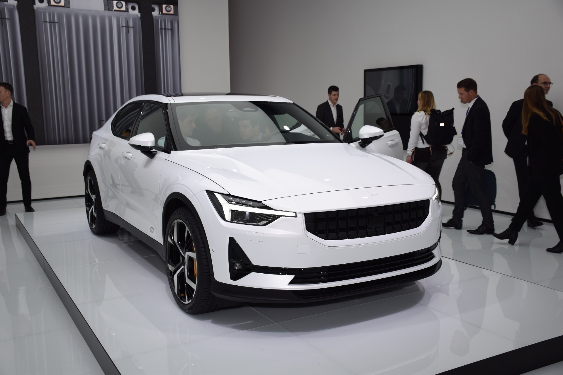 A white Polestar 2 at an auto show
