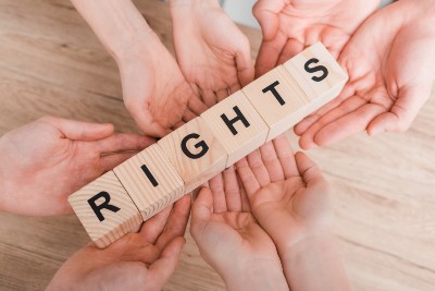 Eight hands hold wood letter blocks that read "rights" - Protesters' rights