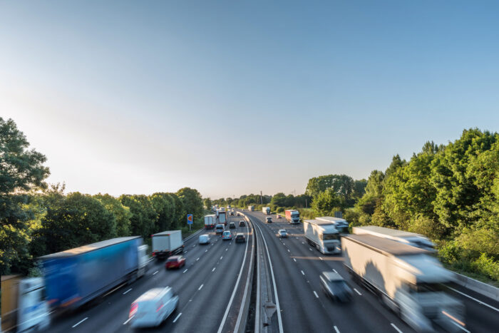 Sunset view heavy traffic moving at speed on UK motorway in England.