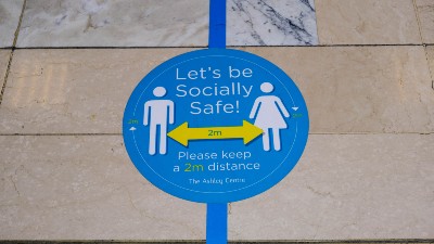 Stickers on the ground remind people to maintain social distancing - england lockdown